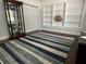 Cozy living room featuring a striped rug, a display cabinet and built-in bookshelves at 209 Rosery Rd, Belleair, FL 33756