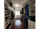 Well-organized walk-in closet with custom shelving for shoes, clothes, and accessories at 209 Rosery Rd, Belleair, FL 33756