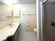 Bright bathroom with a single sink vanity, tiled floors, and a walk-in shower at 210 N Saint Thomas Cir, Apollo Beach, FL 33572