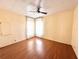 A bright bedroom featuring wood floors, a ceiling fan, and natural light from windows with curtains at 210 N Saint Thomas Cir, Apollo Beach, FL 33572