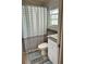 Efficient bathroom layout with decorative shower curtain and mosaic window detail at 21034 Lirio Dr, Land O Lakes, FL 34637