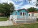 Exterior elevation featuring a light blue home with a welcoming front porch and lush green lawn at 21034 Lirio Dr, Land O Lakes, FL 34637