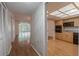 Hallway and entryway offer a view of the living room and kitchen. The kitchen has oak cabinets and black appliances at 2436 Rhodesian Dr # 24, Clearwater, FL 33763
