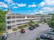 Spacious condominium complex featuring a beige exterior, ample parking, and lush landscaping in a vibrant community at 2436 Rhodesian Dr # 24, Clearwater, FL 33763