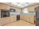 A well-equipped kitchen boasts wood cabinets, black appliances, and abundant counter space, creating an efficient cooking environment at 2436 Rhodesian Dr # 24, Clearwater, FL 33763