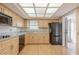 Bright kitchen with wood cabinets, black appliances, and ample counter space is perfect for cooking and entertaining guests at 2436 Rhodesian Dr # 24, Clearwater, FL 33763