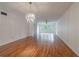 A spacious living room boasts hardwood floors and a modern chandelier, creating a welcoming and stylish space for relaxation at 2436 Rhodesian Dr # 24, Clearwater, FL 33763