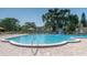 Outdoor swimming pool with lounge seating, surrounded by lush greenery, perfect for relaxation and recreation at 2436 Rhodesian Dr # 24, Clearwater, FL 33763