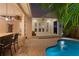 Outdoor entertaining area featuring a pool, bar seating and multiple outdoor living areas with lighting for evenings at 2714 W Jetton Ave, Tampa, FL 33629