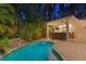Backyard with a private pool, rock waterfall feature, and outdoor bar area with barstool seating at 2714 W Jetton Ave, Tampa, FL 33629