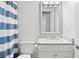 White bathroom with updated sink, marble countertops, and striped shower curtain at 2714 W Jetton Ave, Tampa, FL 33629