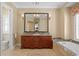 Spacious bathroom featuring tiled floor, double vanity, large mirror, bathtub, and natural light at 2714 W Jetton Ave, Tampa, FL 33629