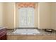 Bathroom with a stand alone tub, tiled surround, and white shuttered windows for natural light at 2714 W Jetton Ave, Tampa, FL 33629