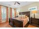 Bedroom featuring hardwood floors, large windows with shades, and wooden furniture at 2714 W Jetton Ave, Tampa, FL 33629
