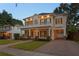 Stately two-story home featuring a covered front porch, manicured lawn, and a brick-paved driveway and walkway at 2714 W Jetton Ave, Tampa, FL 33629