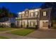 Elegant two-story home with covered porch, balcony, well-manicured lawn, and paver driveway set at twilight at 2714 W Jetton Ave, Tampa, FL 33629