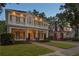 Elegant two-story house featuring a cozy balcony, arched porch, and lush lawn at 2714 W Jetton Ave, Tampa, FL 33629