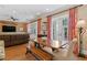 Open living room with hardwood floors, leather sofa, bright curtains, and a view of the backyard at 2714 W Jetton Ave, Tampa, FL 33629