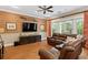 Living room features a leather sofa, tv, mounted oars, hardwood floors, and neutral colors at 2714 W Jetton Ave, Tampa, FL 33629