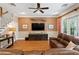 Open living room with hardwood floors, leather sofa, bright curtains, and a view of the staircase at 2714 W Jetton Ave, Tampa, FL 33629