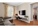 Home office with modern desk, large screen television, sofa and natural light from shuttered window at 2714 W Jetton Ave, Tampa, FL 33629