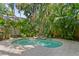 Secluded pool surrounded by tropical landscaping and a stone waterfall feature provides a tranquil backyard oasis at 2714 W Jetton Ave, Tampa, FL 33629
