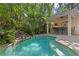Beautiful backyard oasis with a freeform pool, outdoor kitchen, and tropical landscaping at 2714 W Jetton Ave, Tampa, FL 33629
