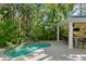 Backyard pool area, featuring a built-in outdoor kitchen and lush tropical landscaping at 2714 W Jetton Ave, Tampa, FL 33629