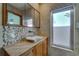 This updated bathroom features a unique vessel sink, granite counters, and stylish mosaic tile backsplash at 2788 70Th S Ave, St Petersburg, FL 33712
