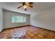 Bright bedroom with terracotta tile flooring, ceiling fan, and a large window with lush outdoor views at 2788 70Th S Ave, St Petersburg, FL 33712