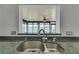 Kitchen sink with granite counters, stainless steel faucet, and serene water view from the bright sunroom beyond at 2788 70Th S Ave, St Petersburg, FL 33712