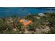 Aerial view of coastal home with a pool, surrounded by mature trees and backing onto the water at 2834 Pelham N Rd, St Petersburg, FL 33710