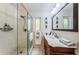 White bathroom featuring a walk-in shower with a glass door and a single sink vanity at 2834 Pelham N Rd, St Petersburg, FL 33710