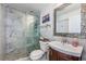 Updated bathroom features marble walls, glass-enclosed shower, and wood vanity at 2834 Pelham N Rd, St Petersburg, FL 33710