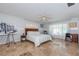 Spacious bedroom featuring travertine floors, light blue walls, a ceiling fan, and natural light at 2834 Pelham N Rd, St Petersburg, FL 33710