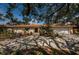 Charming single-story home featuring a red tile roof, a well-manicured lawn and mature trees at 2834 Pelham N Rd, St Petersburg, FL 33710