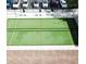 Overhead view of a bocce ball court with green turf, benches, and umbrellas near the parking area at 3137 Mission Grove Dr # 3137, Palm Harbor, FL 34684