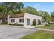 Condo building with neutral paint, manicured landscaping, sidewalk, and adjacent parking spots at 3137 Mission Grove Dr # 3137, Palm Harbor, FL 34684