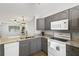 Charming kitchen with grey cabinets, granite countertops, and stainless-steel appliances at 3137 Mission Grove Dr # 3137, Palm Harbor, FL 34684