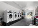 Bright laundry room with rows of modern washing machines and natural light from a large window at 3137 Mission Grove Dr # 3137, Palm Harbor, FL 34684