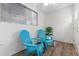 The porch includes two teal Adirondack chairs, natural light, and plank flooring at 3137 Mission Grove Dr # 3137, Palm Harbor, FL 34684