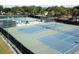 An aerial view showcases a series of well-maintained blue and green tennis courts with mature landscaping at 3137 Mission Grove Dr # 3137, Palm Harbor, FL 34684