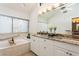 Bright bathroom features double sink vanity with granite counters and soaking tub with vertical blinds at 3342 Waterford Dr, Clearwater, FL 33761