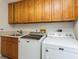 Bright laundry room with modern appliances, wooden cabinetry, and a stainless steel sink at 3342 Waterford Dr, Clearwater, FL 33761
