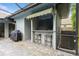 Outdoor kitchen features a built-in bar and grill with seating for entertaining at 3342 Waterford Dr, Clearwater, FL 33761