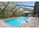 Screened-in pool with brick pavers and lush landscaping creates a backyard oasis at 3342 Waterford Dr, Clearwater, FL 33761