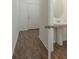 A bathroom featuring wood-look floors, a pedestal sink, and white walls for a clean and bright ambiance at 34847 Daisy Meadow Loop, Zephyrhills, FL 33541