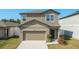 Charming two-story home featuring a two-car garage, well-maintained lawn, and attractive modern architecture at 34847 Daisy Meadow Loop, Zephyrhills, FL 33541