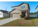 Attractive two-story home with a two-car garage, front yard, and a welcoming front entrance at 34847 Daisy Meadow Loop, Zephyrhills, FL 33541