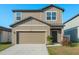 Inviting two-story home featuring a neutral color palette, attached garage, and neat landscaping at 34847 Daisy Meadow Loop, Zephyrhills, FL 33541